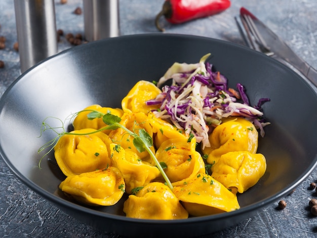 Mooie gele kippenbollen met salade in een donkere plaat