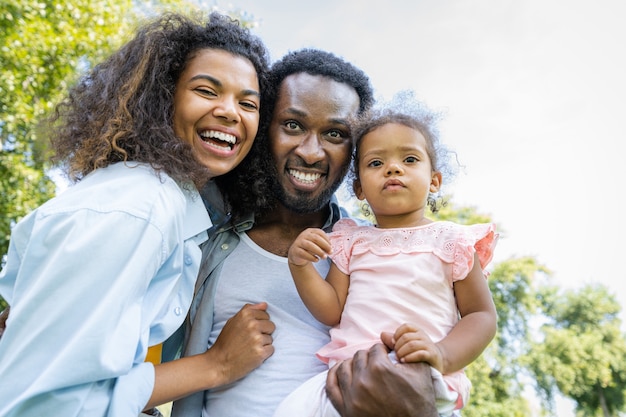Mooie gelukkige Afro-Amerikaanse familiebinding in het park - Zwarte familie die buiten plezier heeft