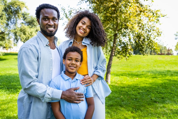 Mooie gelukkige Afro-Amerikaanse familiebinding in het park - Zwarte familie die buiten plezier heeft