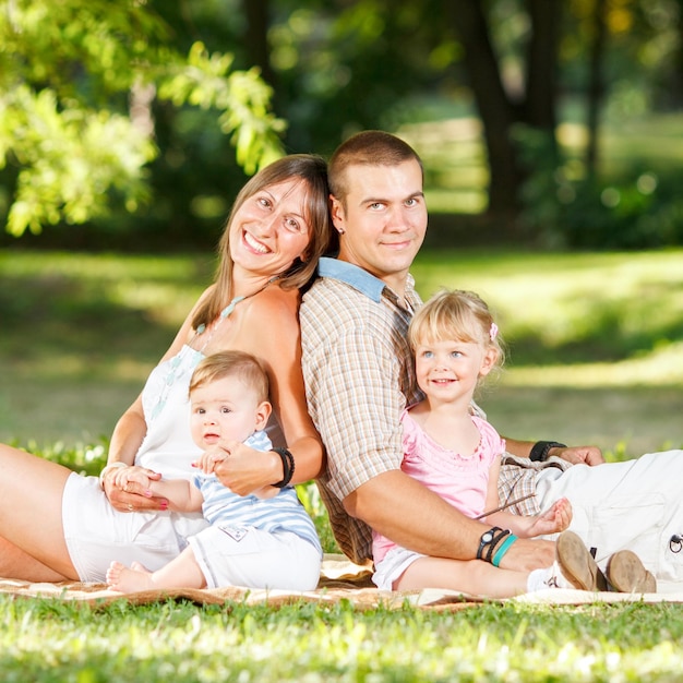 Mooie gelukkige familie die in het park rust