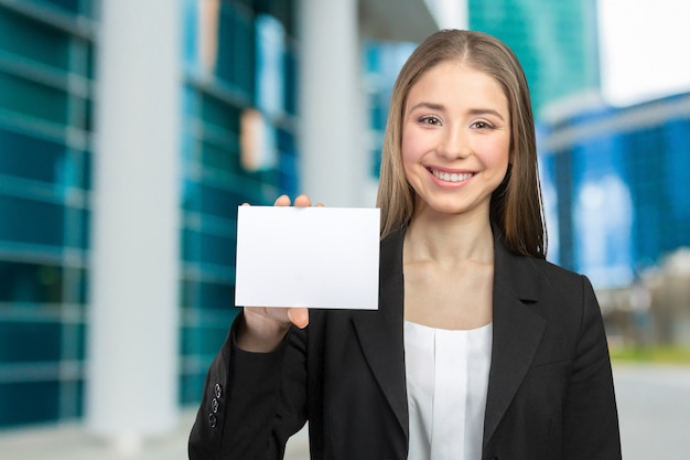 Mooie gelukkige glimlachende vrouw die exemplaarruimte toont