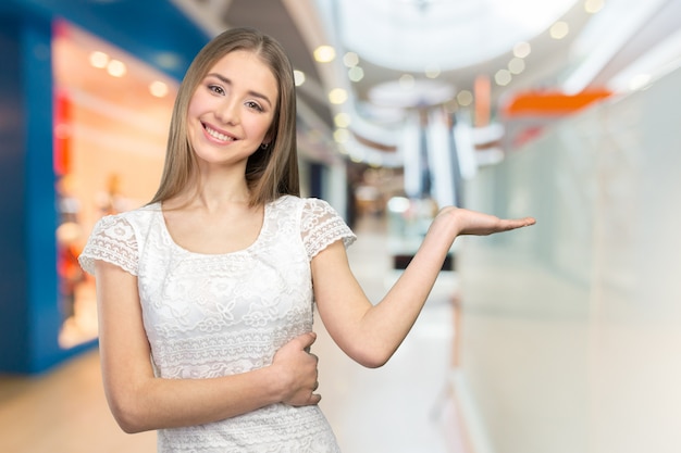 Mooie gelukkige glimlachende vrouw die exemplaarruimte toont