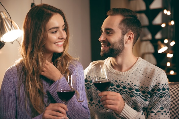 Mooie gelukkige jonge paar romantische avond samen thuis doorbrengen, rode wijn drinken, roosteren