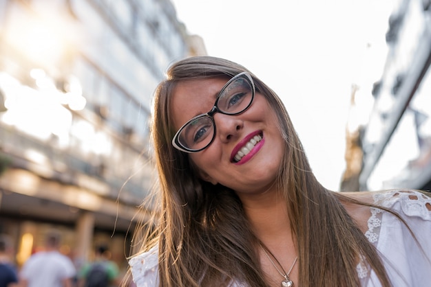 Mooie gelukkige jonge vrouw die in de stad loopt