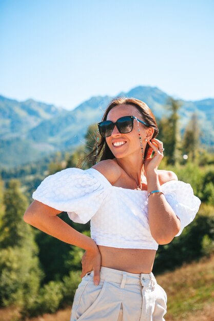 Mooie gelukkige jonge vrouw in de bergen op vakantie. Prachtig landschap