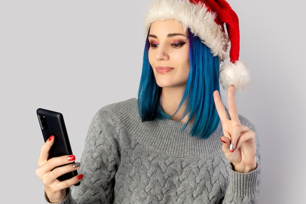 Mooie gelukkige jonge vrouw in kerstmuts selfie te nemen. Kerstmis Nieuwjaar viering concept
