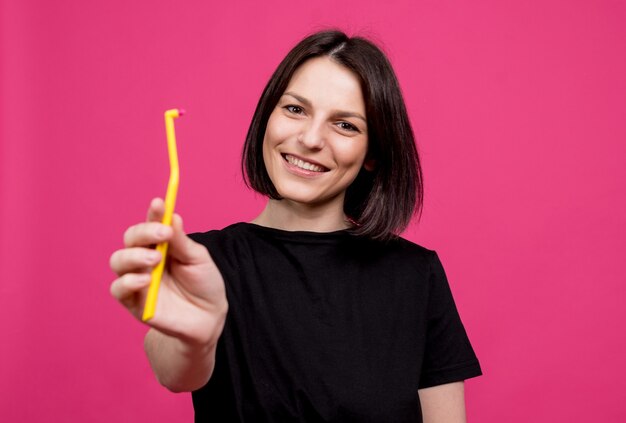 Mooie gelukkige jonge vrouw met enkele getufte tandenborstel