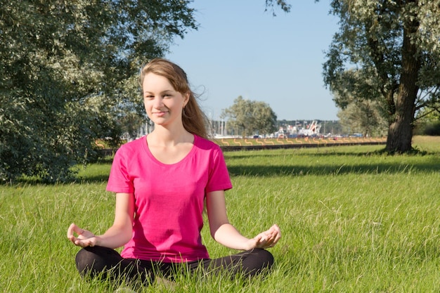 Mooie gelukkige jonge vrouw zitten in park