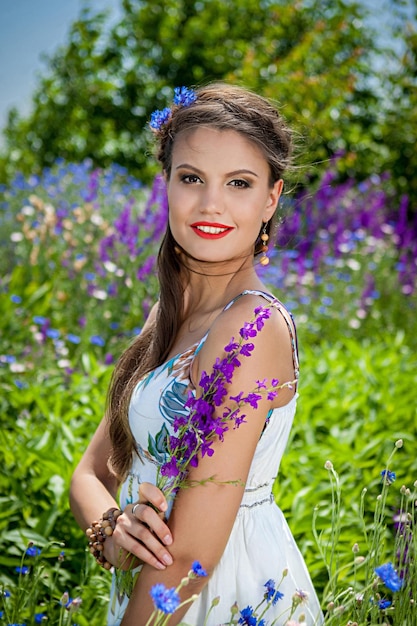 Mooie gelukkige vrouw in de wilde bloemen