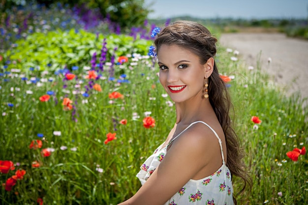 Mooie gelukkige vrouw in de wilde bloemen