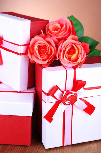 Mooie geschenkdozen met bloemen op tafel op bruine achtergrond