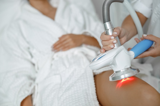 Foto mooie gezonde glimlachende blanke vrouw doet schoonheidsprocedures in de spa en de gezondheidssalon