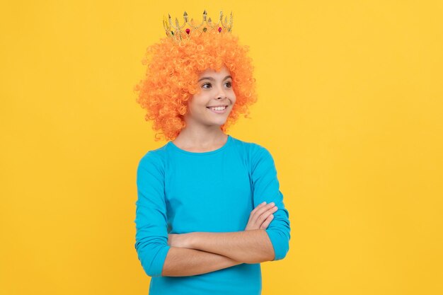 Mooie glimlach stel jezelf een prinses voor grappig kind in diadeem egoïstisch tienermeisje in tiara-verkiezing april dwazen dag gelukkige kindertijd fancy feest kijk egocentrisch kind in clownpruik en kroon