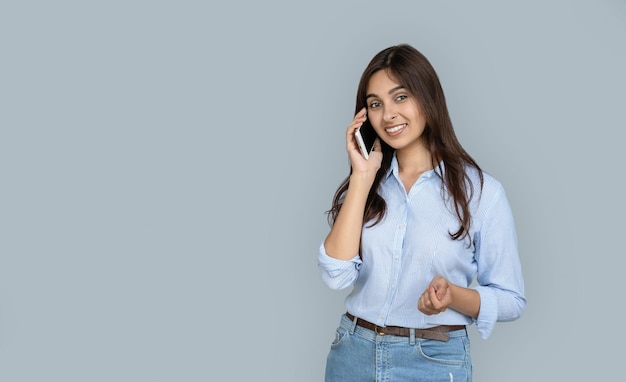 Mooie glimlachende jonge Indiase vrouw praat aan de telefoon gelukkig gezicht geïsoleerd