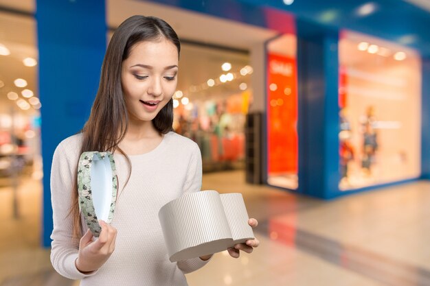 Mooie glimlachende vrouw met lange de giftdoos van de haarholding