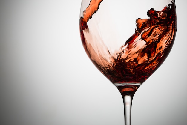 Mooie golven van rode wijn in glasclose-up