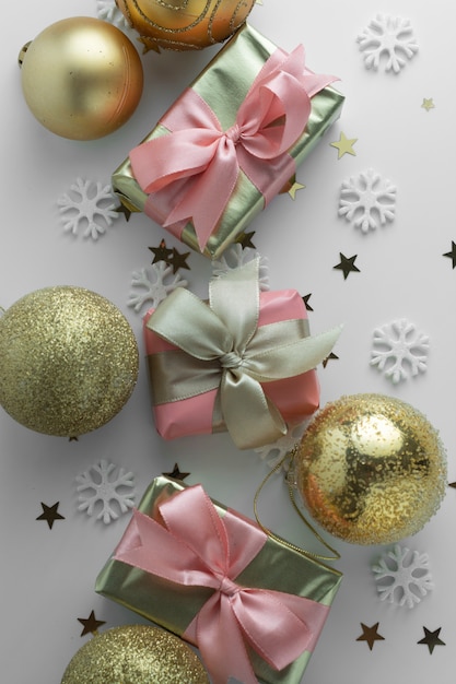 Mooie gouden geschenken gloden kerstballen op wit. Kerstmis, feest, verjaardag achtergrond. Vier glanzende verrassingsdozen copyspace. Creatieve plat lag bovenaanzicht.