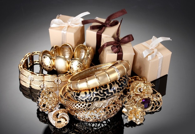 Foto mooie gouden sieraden en geschenken op grijze achtergrond