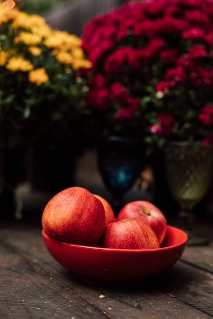 Mooie grote rode appels liggen op een rode plaat op een houten tafel