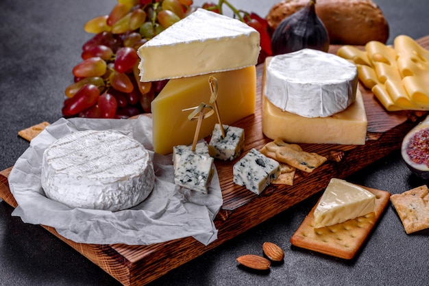 Mooie heerlijke camembert kaas, parmezaan, brie met druiven en vijgen op een houten plank. Snacks voor wijn op vakantie