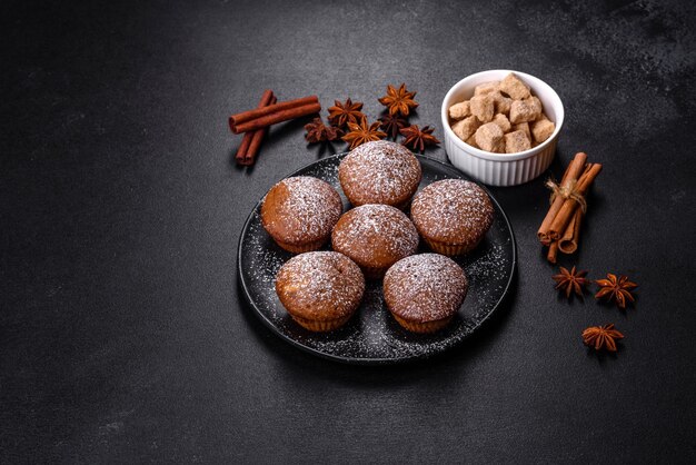 Mooie heerlijke cupcakes met cacao en rozijnen op een zwarte betonnen ondergrond Tijd om thee te drinken