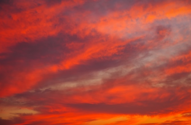 Mooie heldere kleurrijke hemel. Foto genomen bij zonsondergang. Rood-oranje achtergrond met mooie verven. Zeldzame zonsopgang. Natuurlijke samenstelling