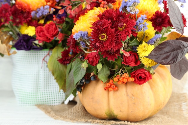 Mooie herfst composities in pompoen en vaas op een houten achtergrond kleur