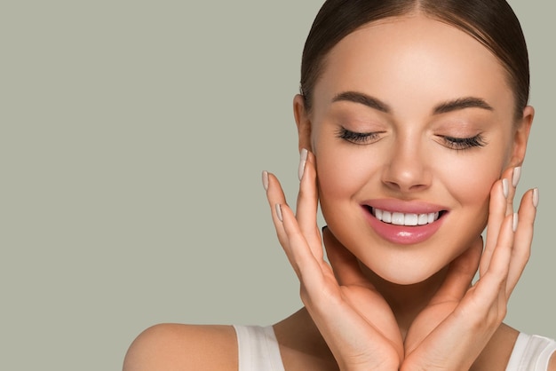 Mooie huid gezicht vrouw natuurlijke make-up gezonde huid aanraken van haar gezicht. Kleur achtergrond. Groente