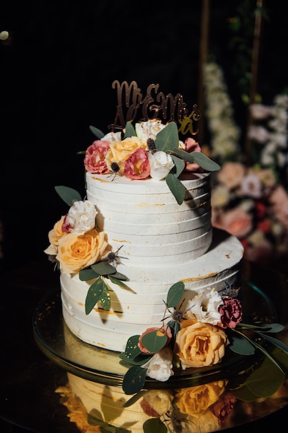 Mooie huwelijksboog met bloemen en een grote bruidstaart