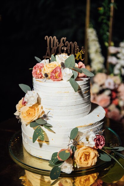 Mooie huwelijksboog met bloemen en een grote bruidstaart