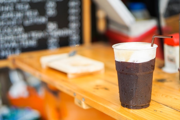 Mooie Iced Americano of zwarte koffie met schuim vormen verse koffiebonen