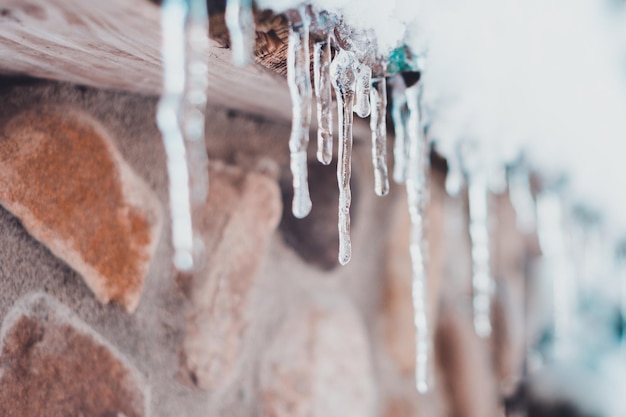 Mooie ijspegel op het dak van een huis in de winter als de temperatuur stijgt