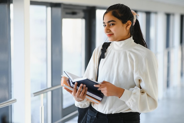 Mooie indiase universiteitsstudent het concept van hoger onderwijs