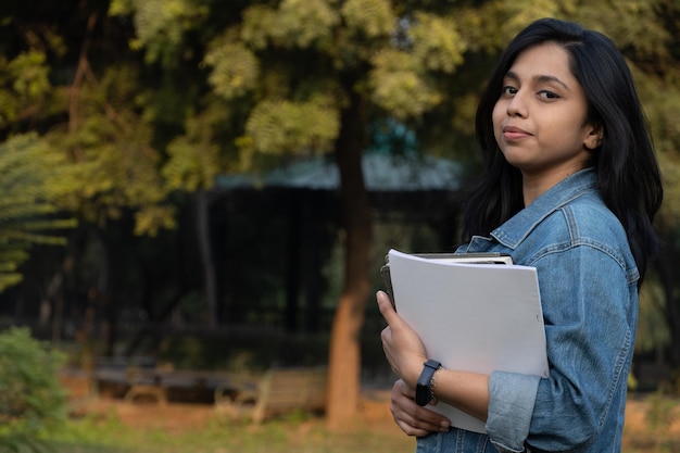 Mooie Indiase vrouw met boeken op de universiteit