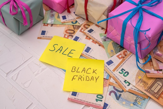 Mooie ingepakte geschenken in heldere wikkels, notitieboekjes en folders met de inscripties zwarte vrijdag en kortingen Black friday-concept