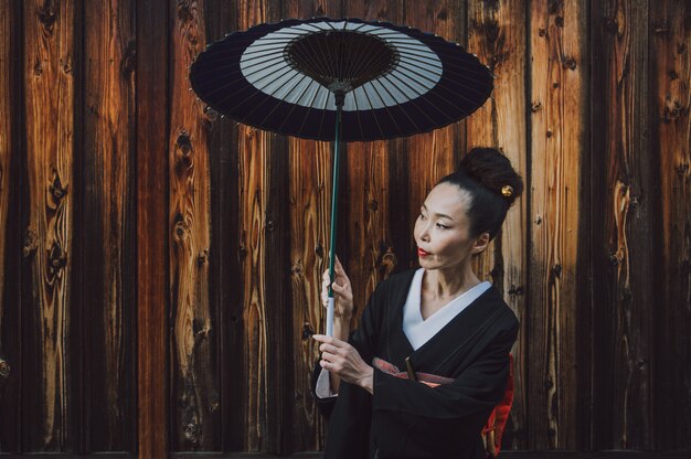 Mooie Japanse hogere vrouw die in het dorp loopt. Typische Japanse traditionele levensstijl