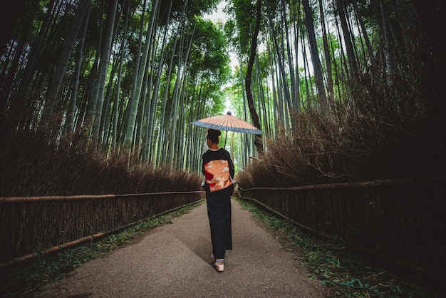 Mooie Japanse senior vrouw lopen in het bamboebos