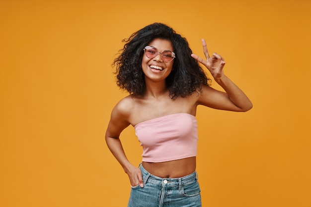 Mooie jonge Afrikaanse vrouw in casual kleding gebaren en glimlachen