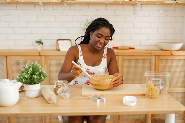 mooie jonge Afrikaanse vrouw koken in de keuken