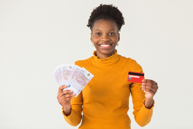mooie jonge Afrikaanse vrouw met euro en creditcard in haar handen