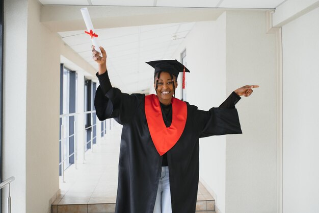 Mooie jonge Afro-Amerikaanse afgestudeerde met diploma