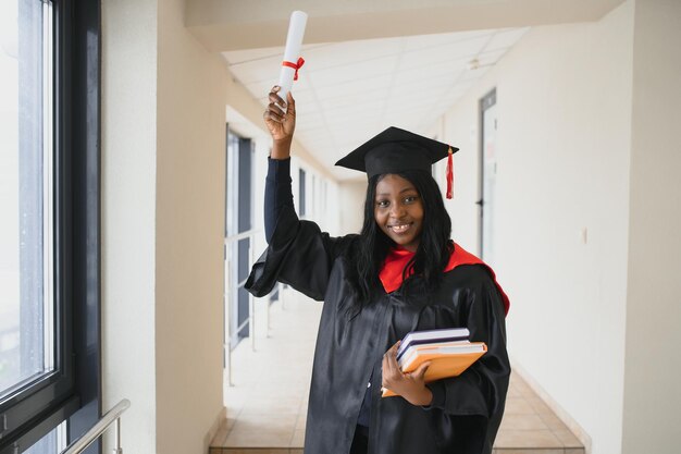 Mooie jonge Afro-Amerikaanse afgestudeerde met diploma