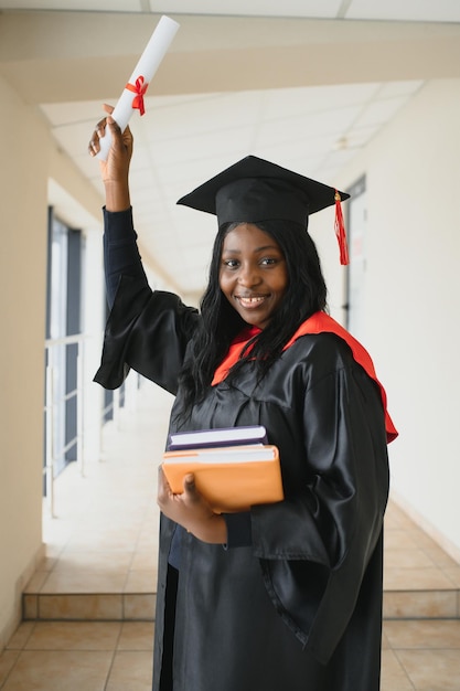 Mooie jonge Afro-Amerikaanse afgestudeerde met diploma