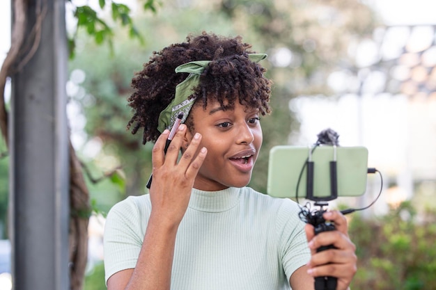 Mooie jonge afro-vrouw die een make-uphandleiding opneemt om te delen op websites of sociale media