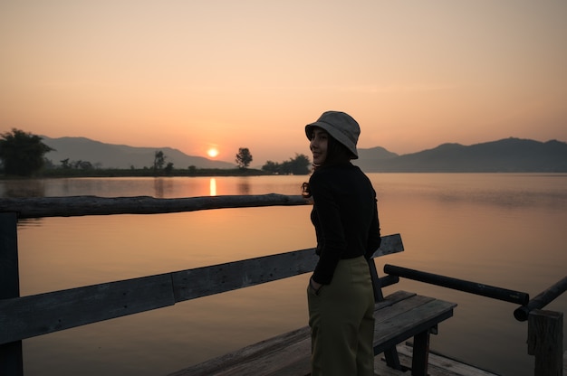 Mooie jonge Aziatische vrouw genieten van met zonsopgang op bergmeer in de ochtend