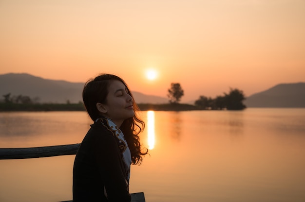 Mooie jonge Aziatische vrouw genieten van met zonsopgang op bergmeer in de ochtend