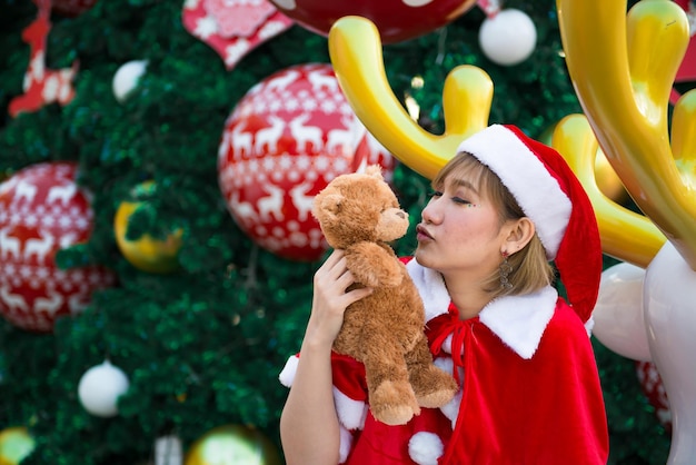 Mooie jonge Aziatische vrouw in Kerstman kleding met teddybeer pop Thailand mensen Verzonden geluk voor kinderen Vrolijk kerstfeest Welkom bij de winter