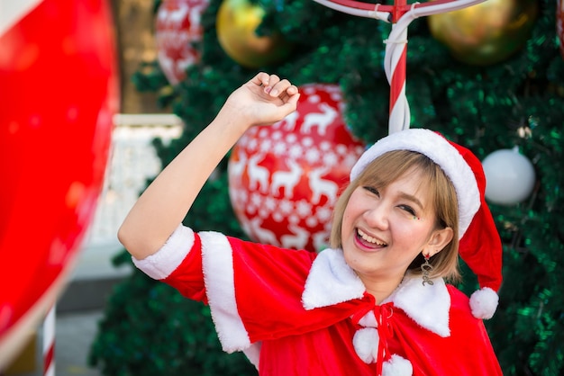 Mooie jonge Aziatische vrouw in Santa Claus-kleding buitenshuis