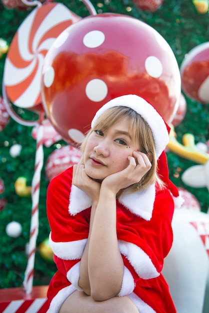 Mooie jonge Aziatische vrouw in Santa Claus-kleding buitenshuis