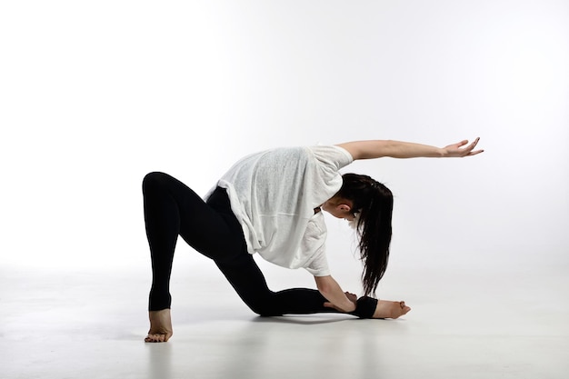 Mooie jonge ballerina dansen op een witte achtergrond